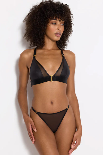Bordelle Vero black sheer mesh thong with gold plated hardware detailing and thin elastic hip straps. Front view on model in matching triangle bra. 