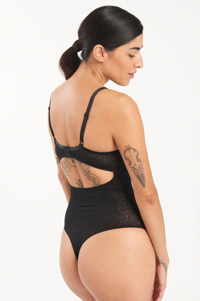 Else Eden black floral mesh underwire bodysuit. Back view on model showing adjustable shoulder straps, hook and eye closure, mid back cutout, and thong bottom.