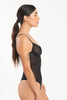 Else Eden black lace mesh bodysuit, side view on model. Image shows the underwired cups, sheer floral pattern lace/mesh, thin elastic adjustable shoulder straps and higher cut thong bottom.