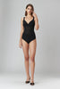 Murmur Grid bodysuit in black stretch muslin. Sleeveless opaque plunge top and bust with sheer midsection, and opaque bottom. Front view on model. 