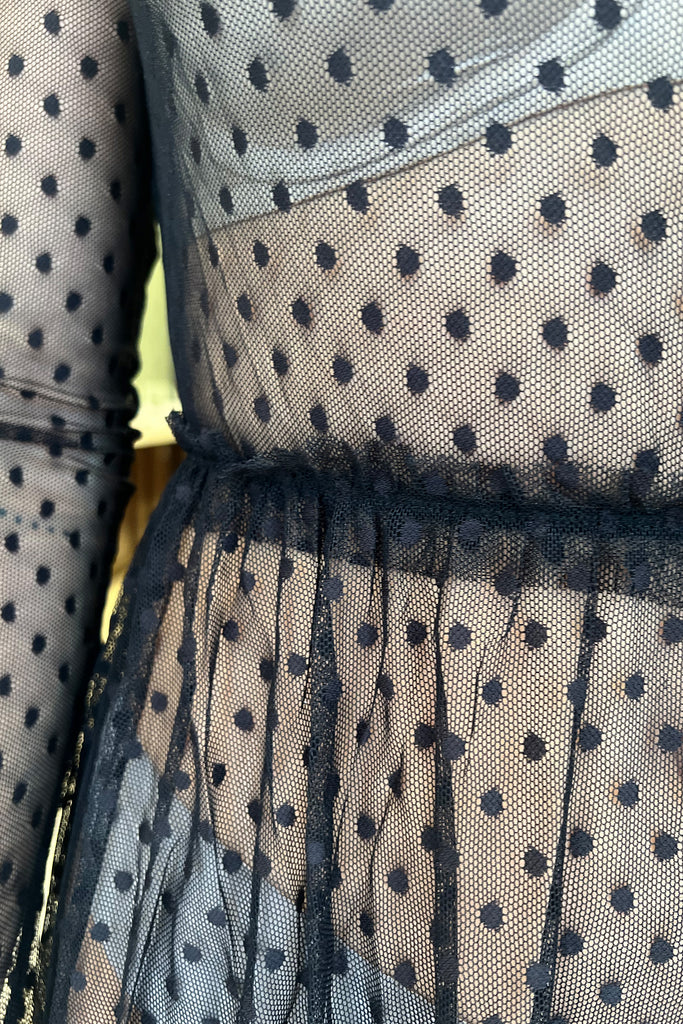 Close up detail of the waist ruffle on the sheer black polka dot Coucou Lola Natasha Tea Dress by Only Hearts, shown on model.