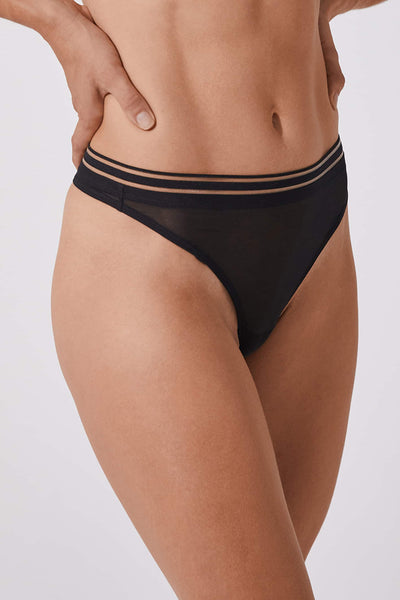 Opaak Anou thong in black sheer mesh, front/side view on model