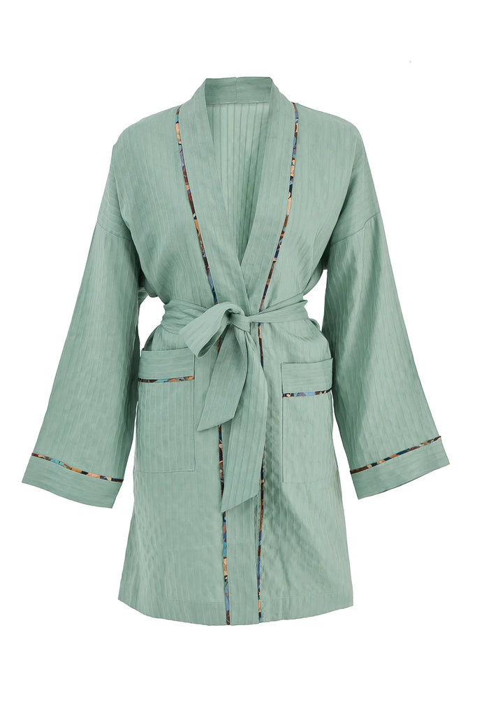 Else Constantinople long sleeve above the knee light green robe with silk print trim on collar, pockets and sleeve cuffs, shown closed with waist tie on plain white background.