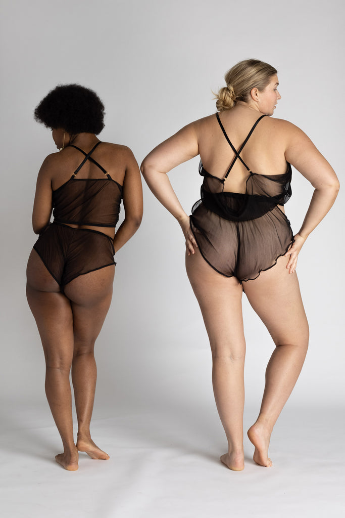 Sheer black Eartha Tap pant shorts with ruffled bottom by Adrina Dietra. The shorts are shown on 2 different models of different sizes illustrating how the tap pants can fit loosely or tightly according to preference and shape. Back view shown with matching camisole.