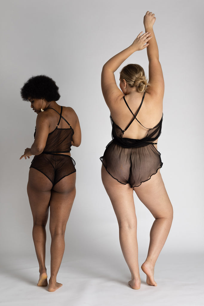Sheer black Eartha cropped camisole by Adrina Dietra. Back view on two models dancing shows how shoulder straps cross in the back.