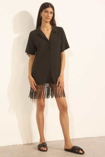 Else Cabo black cotton shirt dress with fringe hem, front view, on model
