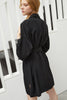 Else Diana black silk robe shown on model, back view. The robe features a pleated detail around the collar and is shown tied at waist. The side slits and drop shoulders are also shown here. 