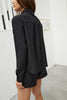 Else Diana silk shirt and shorts set in black. Shown on model, back view. The shirt is buttoned up, has a collar with pleated detail and long sleeves. The shorts have the same pleated detailing at the hemline.