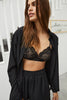 Else Diana silk shirt and shorts set in black. Shown on model, front view. The shirt is unbuttoned showing a black lace bralette, and the shorts have an elastic waistband and a high rise fit.