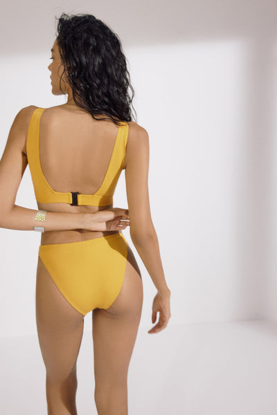 Saffron yellow Mare Classic bikini bottom by Else. Back view on model shows full coverage bottom along with matching swim top.