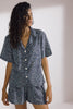 Naxos Camp Shirt by Else, shown buttoned on model with matching shorts. Shirt and shorts are light blue with an abstract dark blue and white print. Shown on model, front view