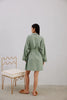 Else Constantinople light green robe, shown on model, back view. Robe has an above the knee hemline and a striped texture weave, with silk trim on the collar and sleeve cuffs. Shown closed with waist tie.