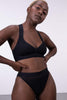 Black opaque 'Baby Blue' soft bra from La Fille d'o, front view on standing model, styled with matching brief underwear.