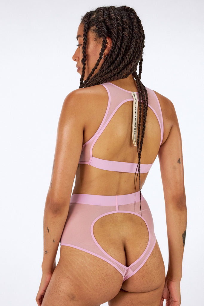 Sheer mesh rose Heroes wireless top by La fille d'O. Back view on model reveals large cutout and thick elastic band at bottom of bra. Shown with matching high waist briefs.