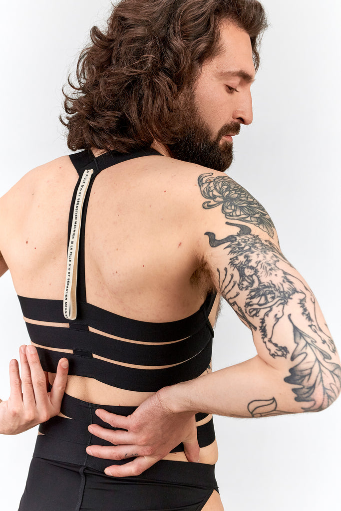 Black night shift ouvert top by La Fille d'O. Back view on model reveals halter straps across the upper back and three thick horizontal straps across the mid back.