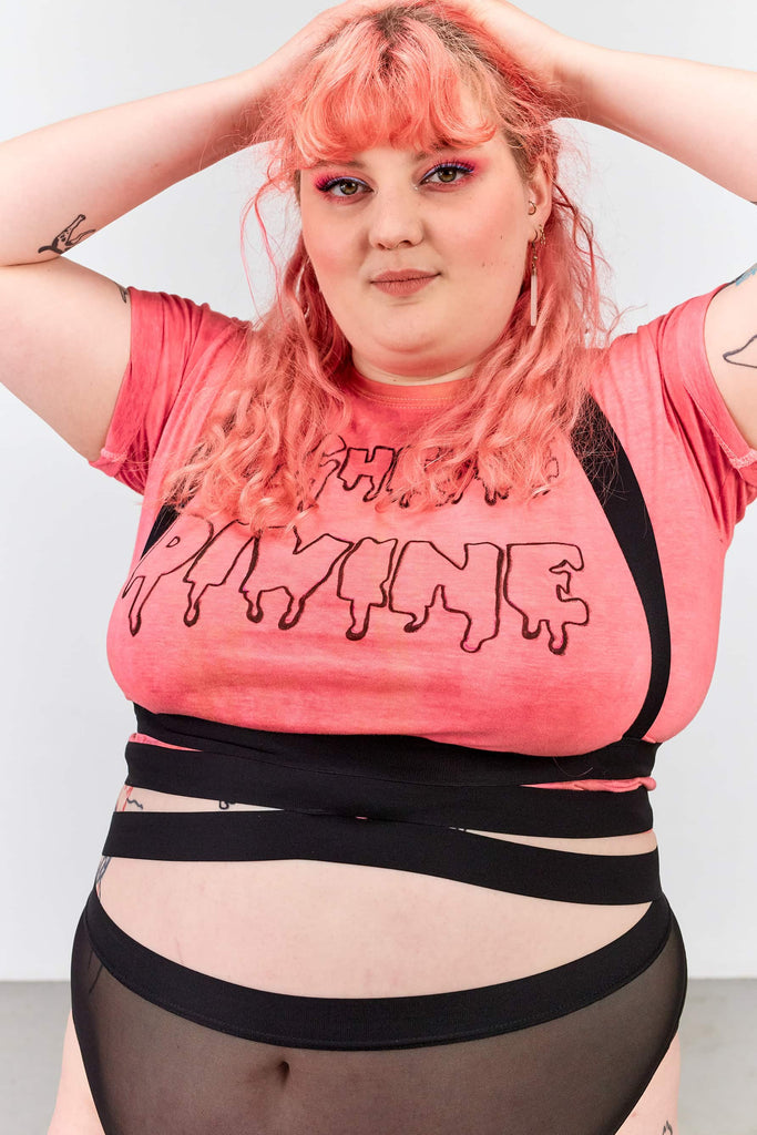 La Fille d'O Pony elastic suspender top/belt in black elastic, front view on model wearing Pony over a hot pink tshirt