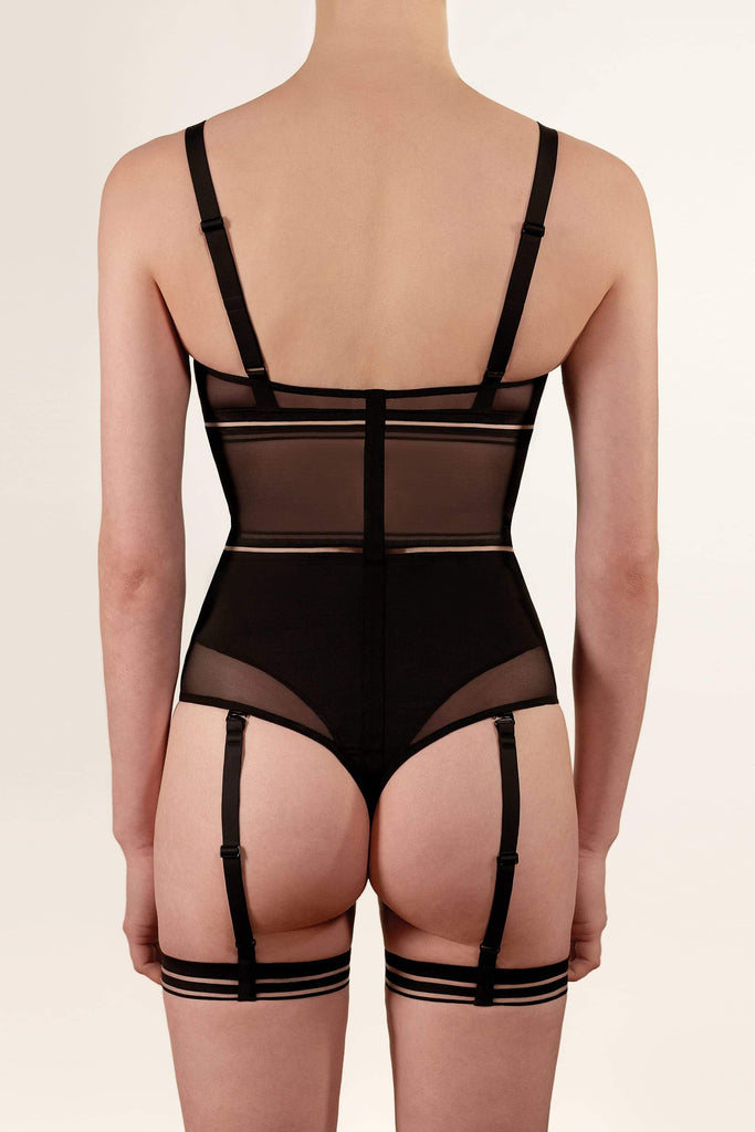 Opaak Lil leg strap garter in black, attached to matching Lux bodysuit, back view, on model