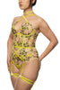 Liana Chartreuse basque with spring floral embroidery, gold plated hardware, and straps that criss cross at the chest and stomach by Studio Pia. Front/side view on model with matching strap thong.