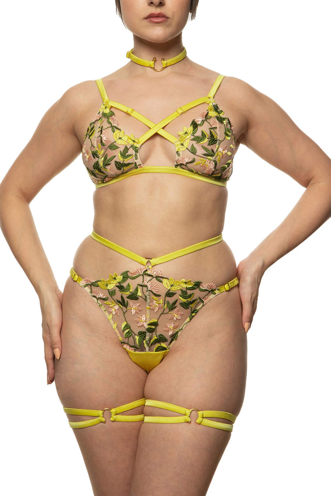 Liana bralette with gold hardware and chartreuse straps that criss cross at the chest by Studio Pia. Soft cups are sheer with spring floral embroidery. Front view on model with matching waist strap knicker.
