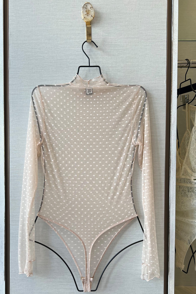 Only Hearts Coucou Lola polka dot mesh sheer bodysuit, back view on hanger. Image shows the long sleeve, turtle neck, high cut leg, thong bottom design. 