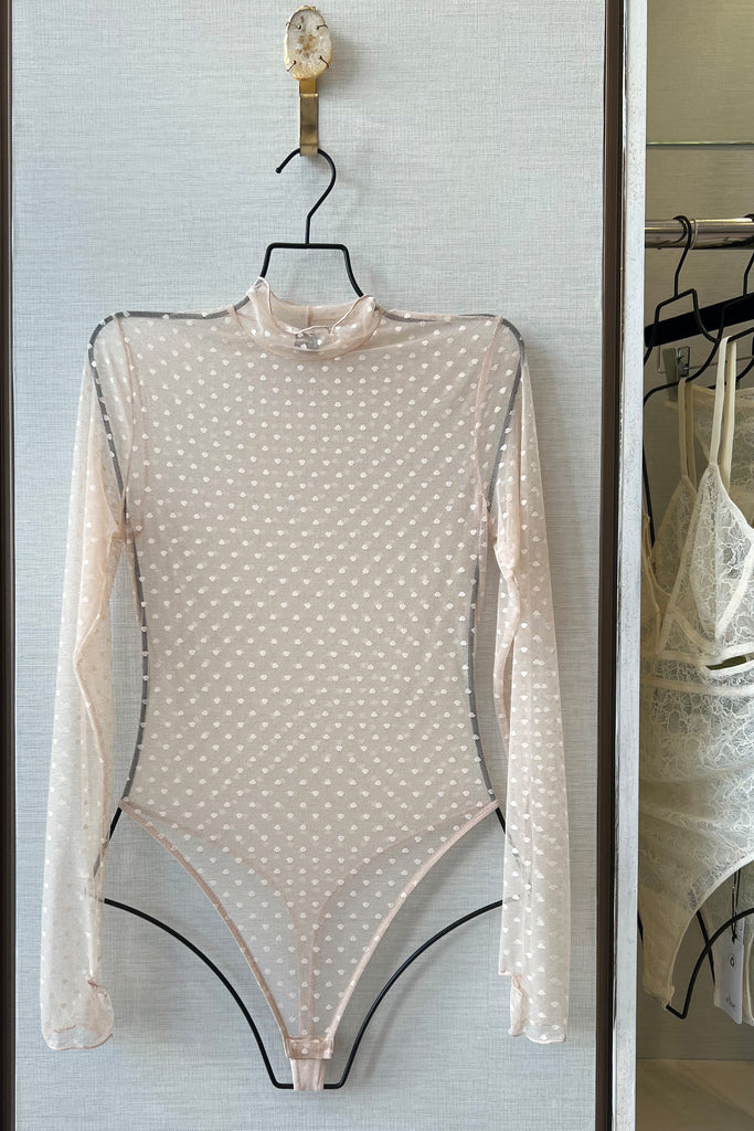 Only Hearts Coucou Lola polka dot mesh sheer bodysuit, front view on hanger. Image shows the long sleeve, turtle neck, high cut leg design. 