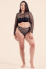 Paloma Casile Gilda Parisian high waist thong in black mosaic style lace. Front view on model in matching long sleeve crop top. Elastic waistband and leg trim. High cut leg and high rise waistband that dips a bit at the center just under the navel.